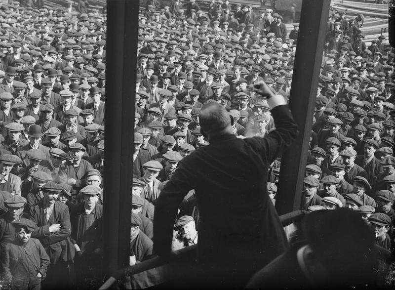 American Federation of Labor delegate, Mr Wilson, is pictured here delivering what looks like a stirring message from US unions to the workers at the shipyard of John Brown & Company on the Clyde. From IWM